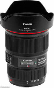 - Location de Studio équipé pour la Photo et la Vidéo Un objectif Canon EF 16-35mm f/4L IS USM avec un pare-soleil. L'objectif est noir avec un anneau rouge près du haut et des indications claires pour la longueur focale et la distance. Les informations de marque et de modèle sont visibles sur le corps de l'objectif.